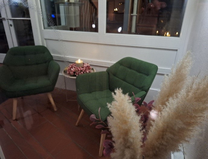 Lounge mit grünen Sesseln und Pampasgras